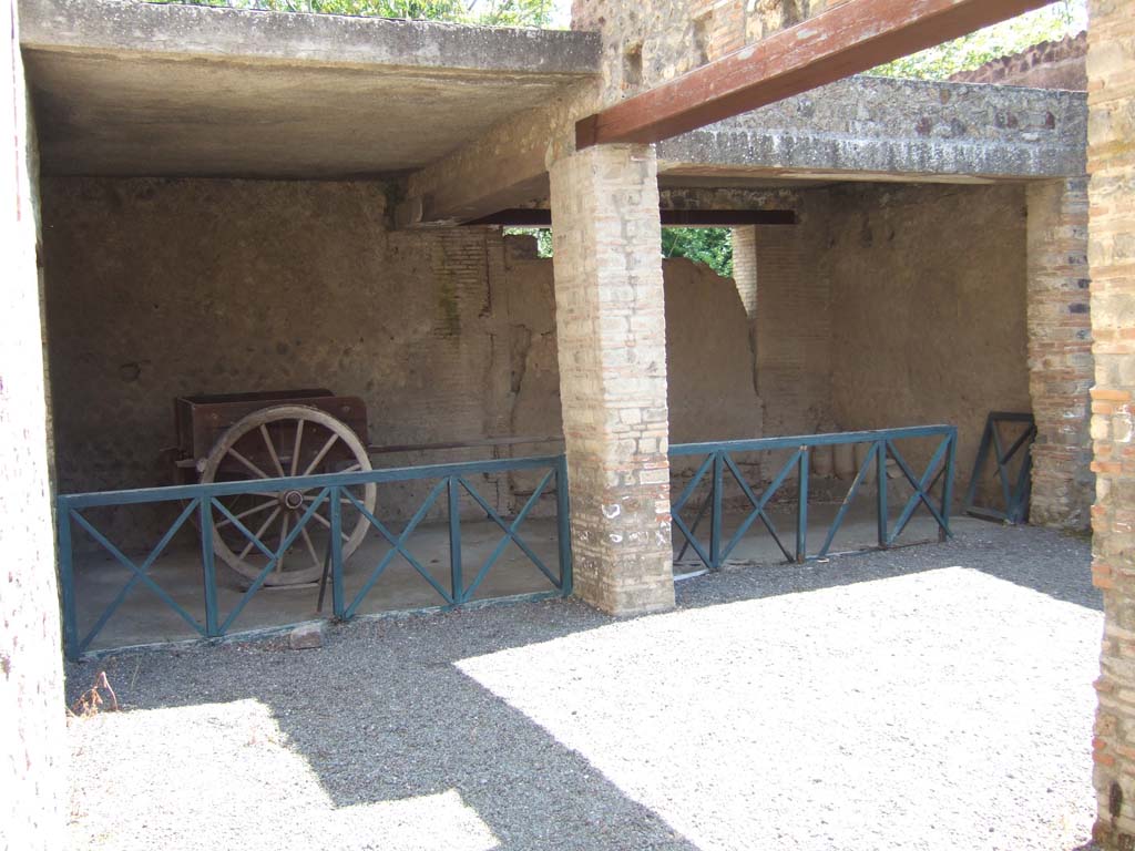I.10.14 Pompeii. May 2006. East side of stable, with two-wheeled cart and blocked doorway.