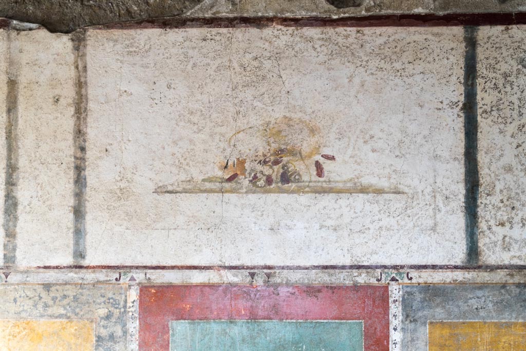 II.1.12 Pompeii. July 2021. 
Triclinium, upper panel from centre of south wall with painting of a fallen basket and dates. Photo courtesy of Johannes Eber.

