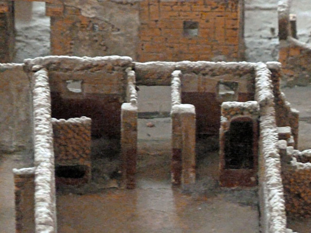 VI.2.22 Pompeii. May 2010. Looking east from atrium, towards entrance at VI.2.22 and doorways to cubicula on either side.
Model as viewed in Naples Archaeological Museum.
