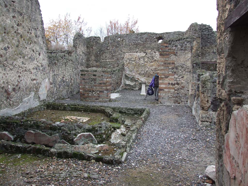VI.7.23 Pompeii. December 2006. Looking west across remains of pyramidal fountain in courtyard on west side of tablinum.  
Painted remains of north wall and window, on right.
