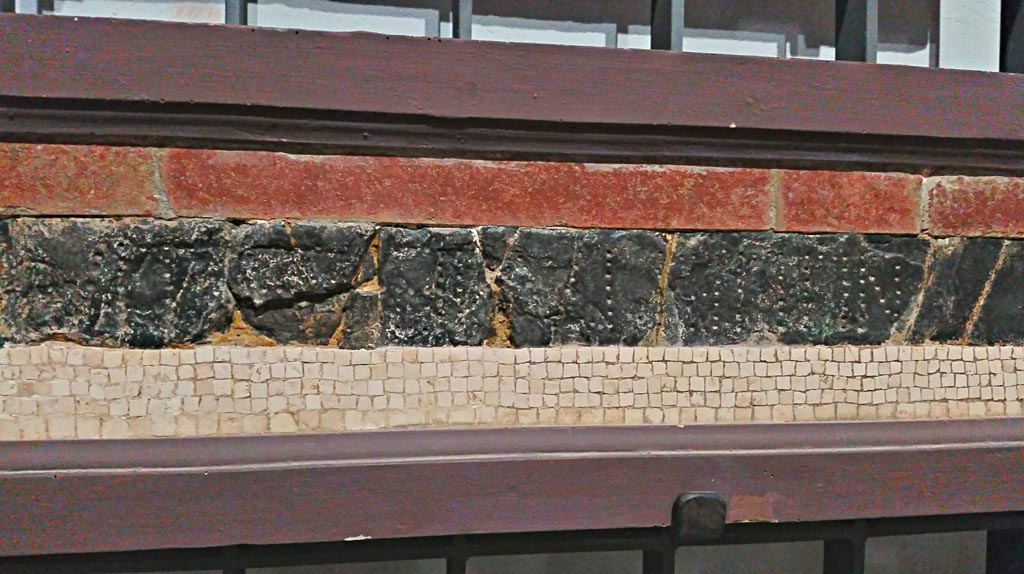 VII.7.32 Pompeii. 
Detail of red and green/black floor mosaic with (part of the) epigraph, on display in Naples Archaeological Museum, inv. 113398.
Photo courtesy of Giuseppe Ciaramella, June 2017.

