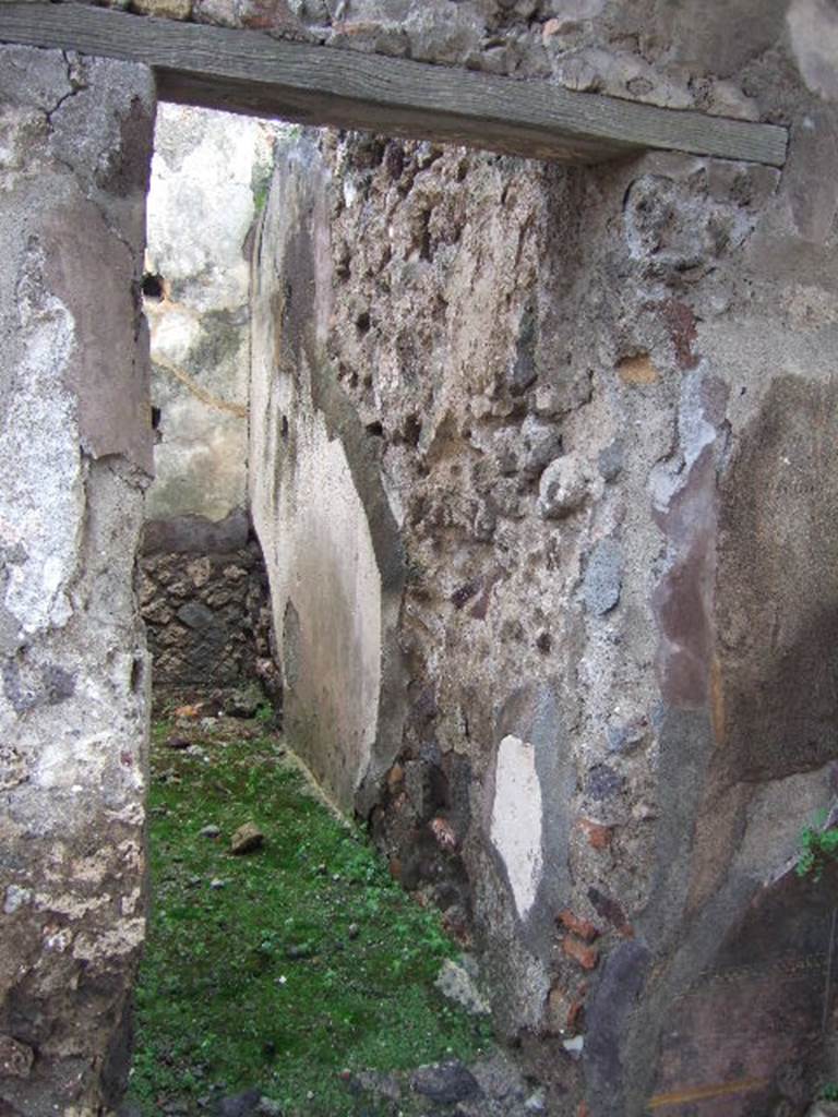 VIII.2.26 Pompeii. December 2005. Doorway to room ‘c’, on east of entrance. When excavated, a black zoccolo with ‘carpet’ border and the middle of wall painted red, could be seen.

