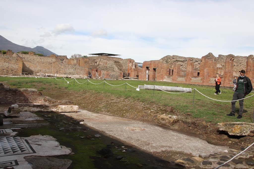 IX.4.18 Pompeii. October 2020. 
Looking towards north-east side of palaestra “d”, from the remains of ancient buildings in the south-west area. 
During the excavation, the archaeologists found the remains of the demolished residential houses in the area of the palaestra, which had not been entirely cleared by the people building the new baths.
According to Mau –
Other testaments of an earlier era consist of various remains of flooring at different levels, in the north portico, near the ancient tank/basin (N and NW) and in the SW corner, and the latter are lower, following the natural slope of the ground. You can also see remains of ancient buildings especially in the north portico, you can see large boulders of Sarno stone with stucco cladding.
See BdI, 1877, p.214-223, (see p.217).
