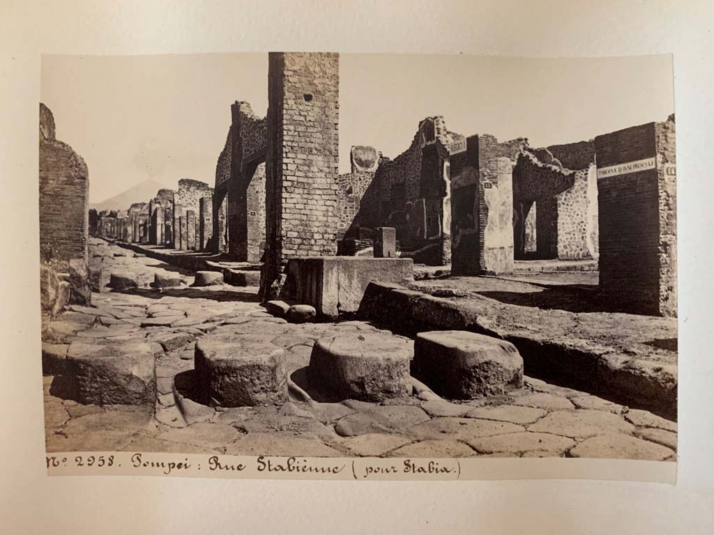 Via Stabiana, Pompeii. Album by M. Amodio, c.1880, entitled “Pompei, destroyed on 23 November 79, discovered in 1748”.
Looking towards fountain outside I.4.15, and continuation of roadway to north. On the right is the Via dell’Abbondanza.
Photo courtesy of Rick Bauer.

