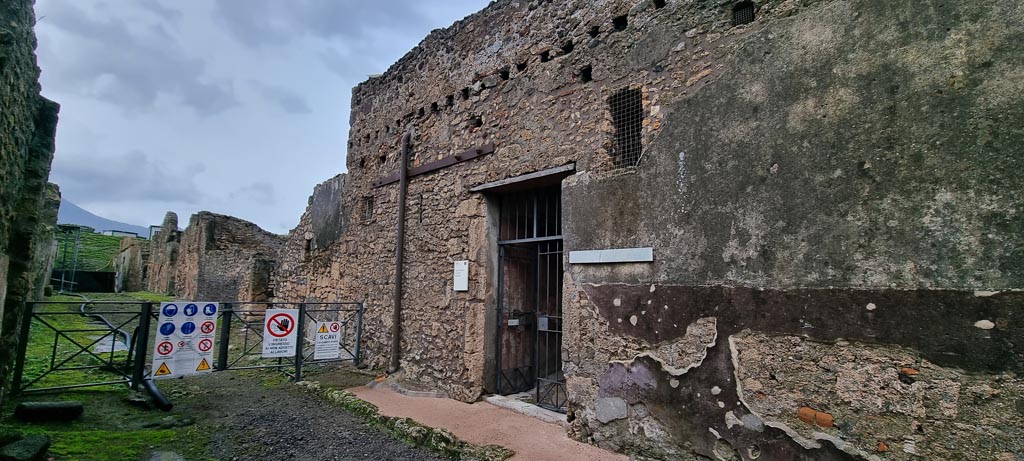 Vicolo di Lucrezio Frontone, east side. January 2023. 
Looking north towards entrance doorway of V.4.a, in centre. Photo courtesy of Miriam Colomer.
