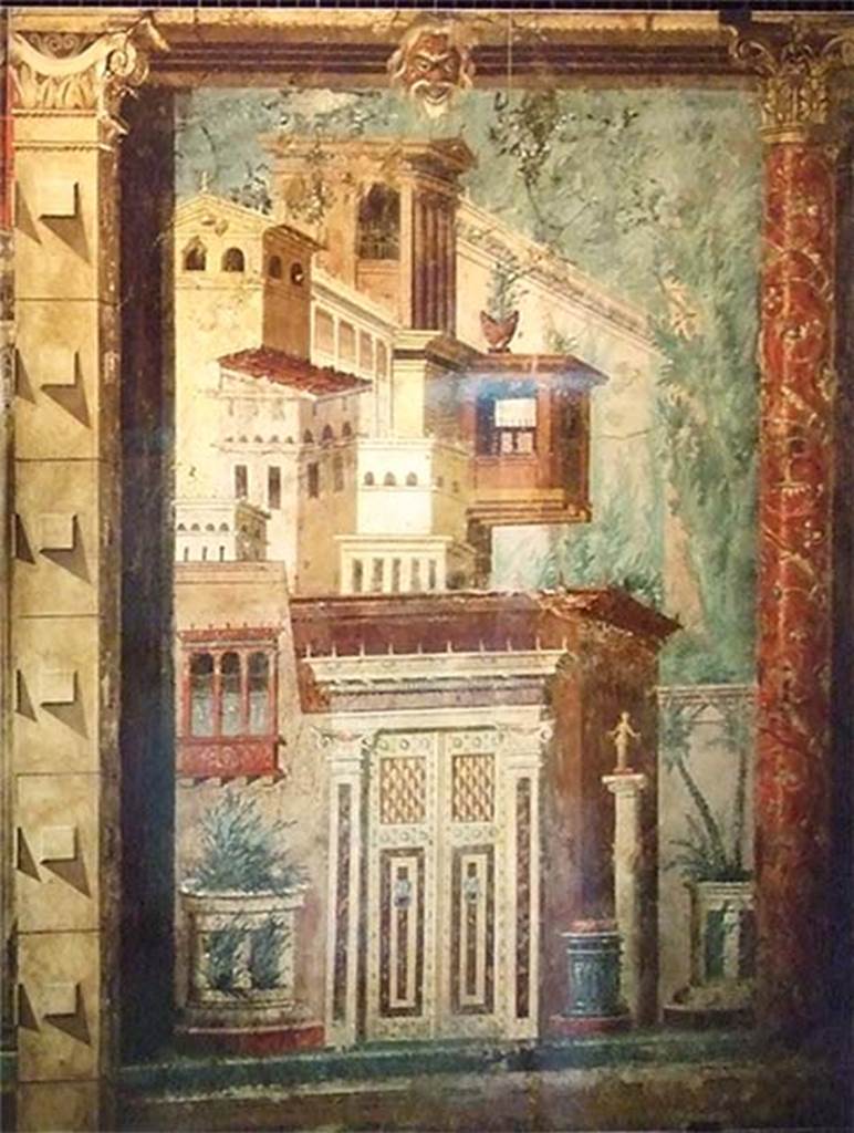 Villa of P Fannius Synistor at Boscoreale. Cubiculum M. Second panel from north end of east wall. Panel painted with buildings, window, an ornate door, an altar and a statue on a column. At the top of the panel is a mask and on the right a red column ornately painted with flowers and climbers. The painting also has a considerable amount of detail not visible in the photo. The square column on the left marks the division between the end of the cubiculum and the start of the alcove. The panel is an analogue of the panel on the opposite wall. See Barnabei F., 1901. La villa pompeiana di P. Fannio Sinistore. Roma: Accademia dei Lincei. p. 71-81.