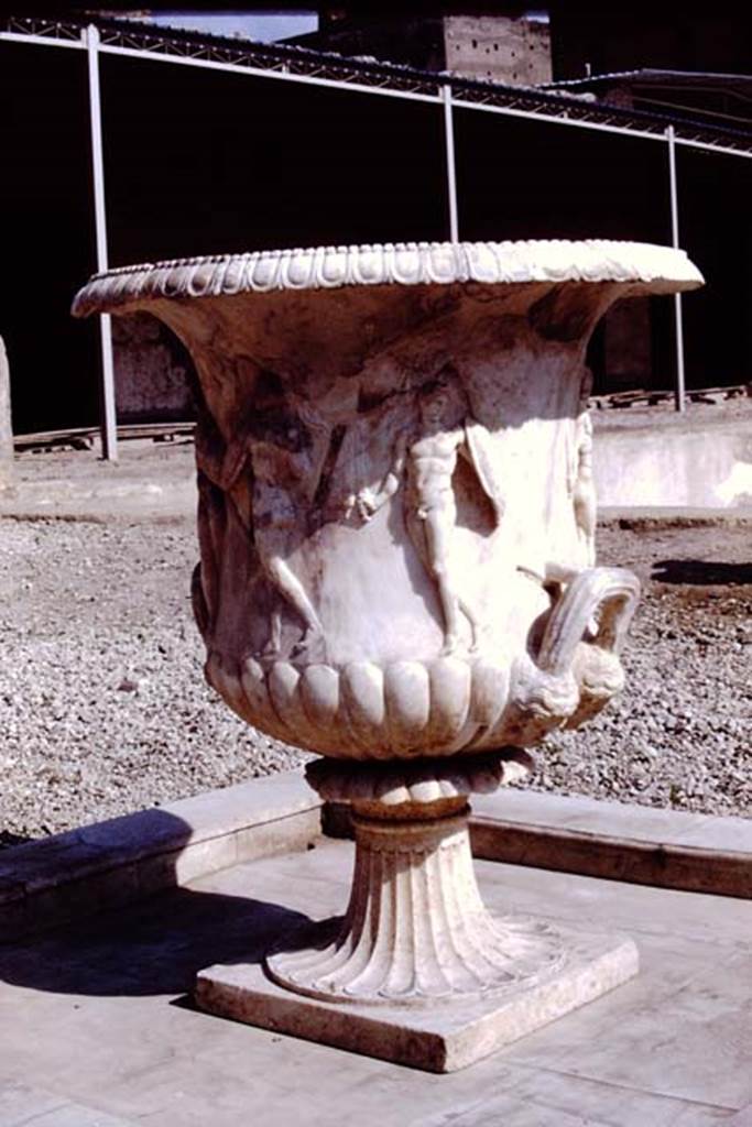 Oplontis Villa of Poppea, 1978. Terrace 92. Large crater fountain vase positioned in the centre of the south side of the pool. 
Photo by Stanley A. Jashemski. 
Source: The Wilhelmina and Stanley A. Jashemski archive in the University of Maryland Library, Special Collections (See collection page) and made available under the Creative Commons Attribution-Non Commercial License v.4. See Licence and use details.
J78f0048
According to Wilhelmina, “We were delighted to see they had discovered the base of the beautiful marble crater fountain in a small pool in the garden area on the south side of the swimming pool where the crater had been originally located. We had admired the fountain on a previous trip, for it had been found earlier, in the rear portico of the villa where it had been stored, possibly after the earthquake.”
See Jashemski, W.F., 2014. Discovering the Gardens of Pompeii: Memoirs of a Garden Archaeologist, (p.263).
According to Wilhelmina, “the base of the large crater fountain was found in fragments in passage 53, where it had been stored at the time of the eruption”.
See Jashemski, W. F., 1993. The Gardens of Pompeii, Volume II: Appendices. New York: Caratzas. (p.298).

