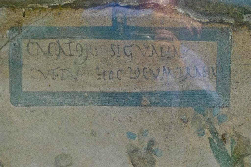 Painted street shrine on the wall at V.6.19. July 2010. Warning to passers-by added to street shrine.
“CACATOR SIC VALEAS VT TV HOC LOCUM TRA(N)SEA(S)”.  CIL IV 6641.
Photo courtesy of Michael Binns.