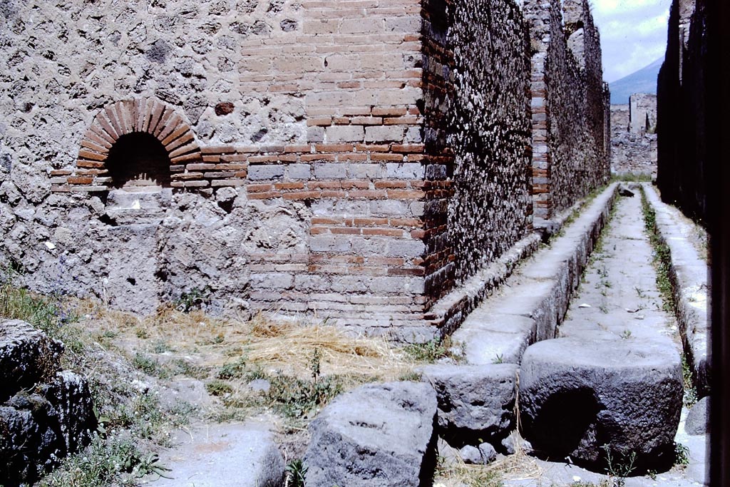 Street altar on south-east corner of IX.4 Pompeii. 1966. 
Looking north from junction with unnamed vicolo, on the left. Photo by Stanley A. Jashemski.
Source: The Wilhelmina and Stanley A. Jashemski archive in the University of Maryland Library, Special Collections (See collection page) and made available under the Creative Commons Attribution-Non-Commercial License v.4. See Licence and use details.
J66f0472