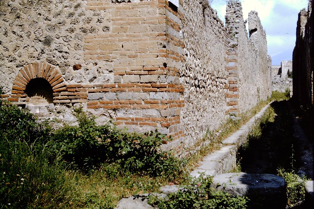 Street altar on south-east corner of IX.4, looking along Vicolo di Tesmo between IX.4 and IX.5, on the right. Pompeii. 1964. 
Looking north from junction with unnamed vicolo, on the left. Photo by Stanley A. Jashemski.
Source: The Wilhelmina and Stanley A. Jashemski archive in the University of Maryland Library, Special Collections (See collection page) and made available under the Creative Commons Attribution-Non-Commercial License v.4. See Licence and use details.
J64f1610