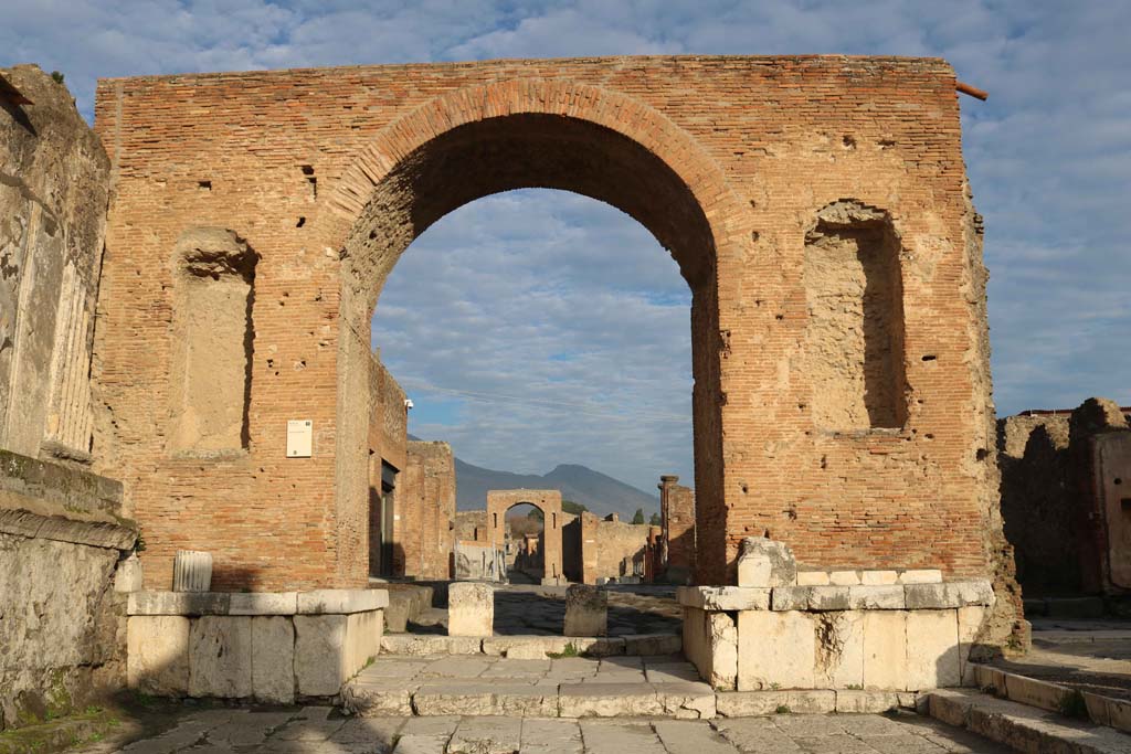 Arch at north-east end of the Forum. December 2018. 
Looking north through arch towards Via del Foro, and on to arch at junction with Via di Mercurio. Photo courtesy of Aude Durand.