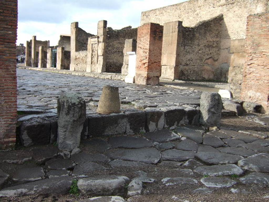 Arch of Marcus Holconius Rufus. December 2005. Remains of pillars of the north side of the arch, on right. Looking west through arch along Via dell’ Abbondanza.