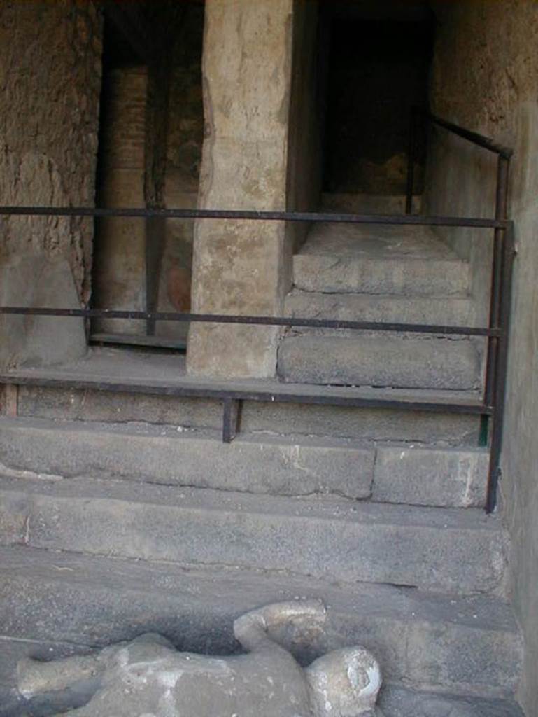 VII.16.17-22 Pompeii. May 2006. 
Looking up towards the stairs where a group of fugitives were found, and where victim 49 still lies at the foot of staircase.