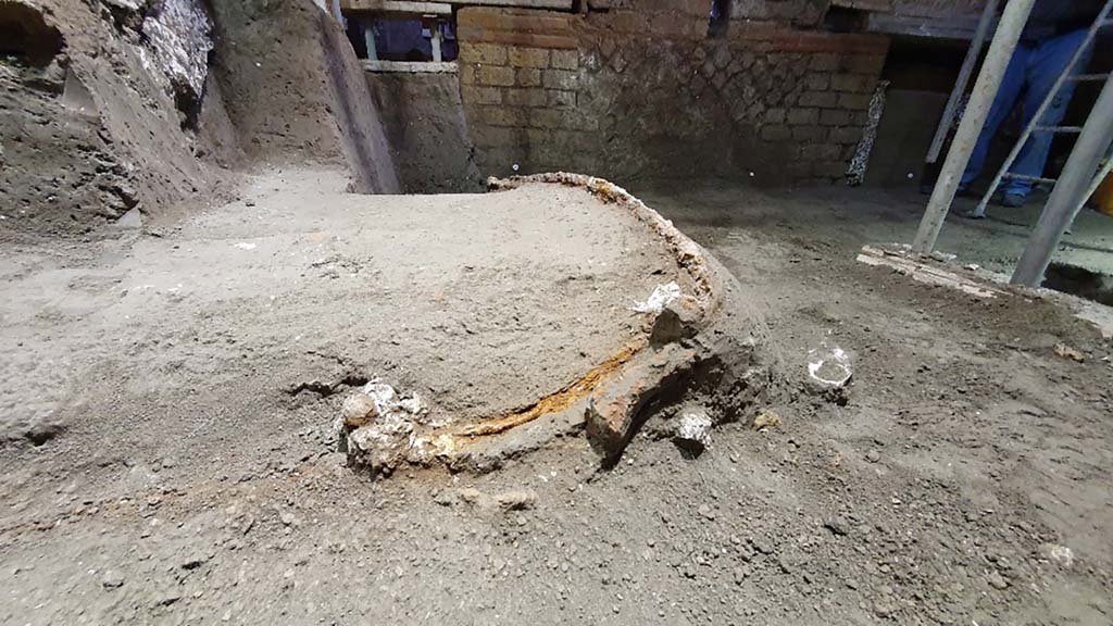 Cività Giuliana. February 2021. The excavation, which proceeded slowly over the following weeks due to the fragility of the elements which were progressively emerging, unearthed a ceremonial chariot, which had miraculously been spared by both the collapse of the walls and ceiling of the room and by the illegal activities, with tunnels passing it by on two sides, but without compromising the structure.
From the moment it was identified, the excavation of the chariot has proved to be particularly complex due to the fragility of the materials involved and the difficult working conditions; as a result, it was necessary to proceed by means of a micro-excavation conducted by the restorers of the Park, who are specialised in the treatment of wood and metals. At the same time, whenever a void was discovered, plaster was poured in as part of an attempt to preserve the imprint of the organic material that was no longer present. Consequently, it has been possible to preserve the shaft and platform of the chariot, as well as the imprints of ropes, thus revealing the chariot in all of its complexity.
Cività Giuliana. Febbraio 2021.  Lo scavo proseguito lentamente nelle settimane successive – per la fragilità degli elementi che si progressivamente emergevano, ha portato alla luce un carro cerimoniale, risparmiato miracolosamente sia dai crolli delle murature e delle coperture dell’ambiente sia dalle attività clandestine, che con lo scavo di due cunicoli lo hanno sfiorano su due lati, senza averne compromessa la struttura.
Sin dal momento della sua individuazione lo scavo del carro si è rivelato particolarmente complesso per la fragilità dei materiali e le difficili condizioni di lavoro; si è quindi dovuto procedere con un vero e proprio microscavo condotto dalle restauratrici del Parco specializzate nel trattamento del legno e dei metalli. Parallelamente, ogni volta che si rinveniva un vuoto, è stato colato del gesso per tentare di preservare l’impronta del materiale organico non più presente. Così si è potuto conservare il timone e il panchetto del carro, ma anche impronte di funi e cordami, restituendo così il carro nella sua complessità.
Photograph © Parco Archeologico di Pompei.