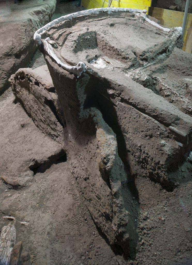 Cività Giuliana. February 2021. 
The layer of cinerite which entombed the chariot had allowed the preservation of its original dimensions and of the individual parts which mark out the connected structure.
The artefact in question is a four-wheeled chariot which, on the basis of information recorded by sources and the few archaeological traces that have otherwise been found to date, can probably be identified as a pilentum, a transport vehicle used in the Roman world by the elites in ceremonial contexts.
Cività Giuliana. Febbraio 2021
La coltre di cinerite che ha sigillato il carro ha permesso la conservazione delle dimensioni originarie e delle singole parti che ne scandiscono la struttura in connessione.
Si tratta di un carro a quattro ruote, probabilmente identificabile sulla base delle notizie tramandate dalle fonti e dei pochi riscontri archeologici ad oggi noti con un Pilentum, un veicolo da trasporto usato nel mondo romano dalle élites in contesti cerimoniali.
Photograph © Parco Archeologico di Pompei.