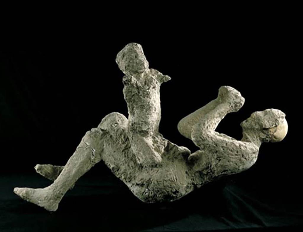 VI.17.42 Pompeii. 1974, cast identified as a woman and child, part of a group of four who died under the staircase.
The group consisted of a man and a woman, who was holding a child, and a few metres away was an older child.
A golden bracelet of exceptional weight and unusual design was found on the arm of the woman.
This gave the name to the house.
All four members of the group have now been identified as male.