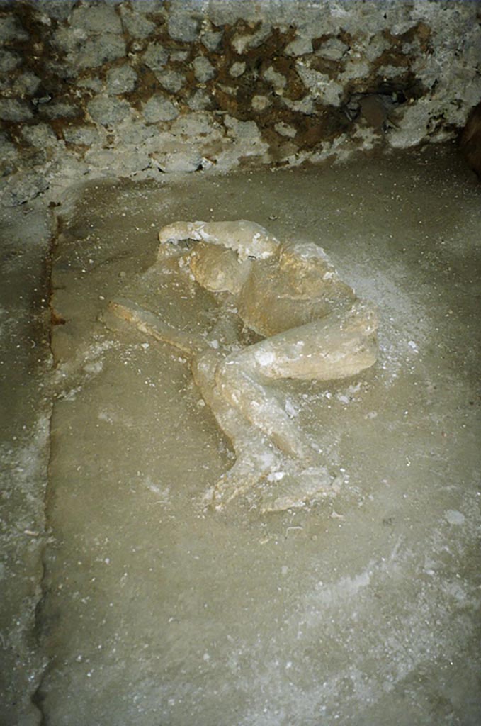 Victim 33. Pompeii, outside Porta Nocera. July 2010. 
Plaster cast of a fourth fleeing victim found in April 1957. 
The chin appears to be covered by a very thin veil-like fabric, while on the left arm there is some drapery. He was wearing lace-up sandals.
Photo courtesy of Rick Bauer.