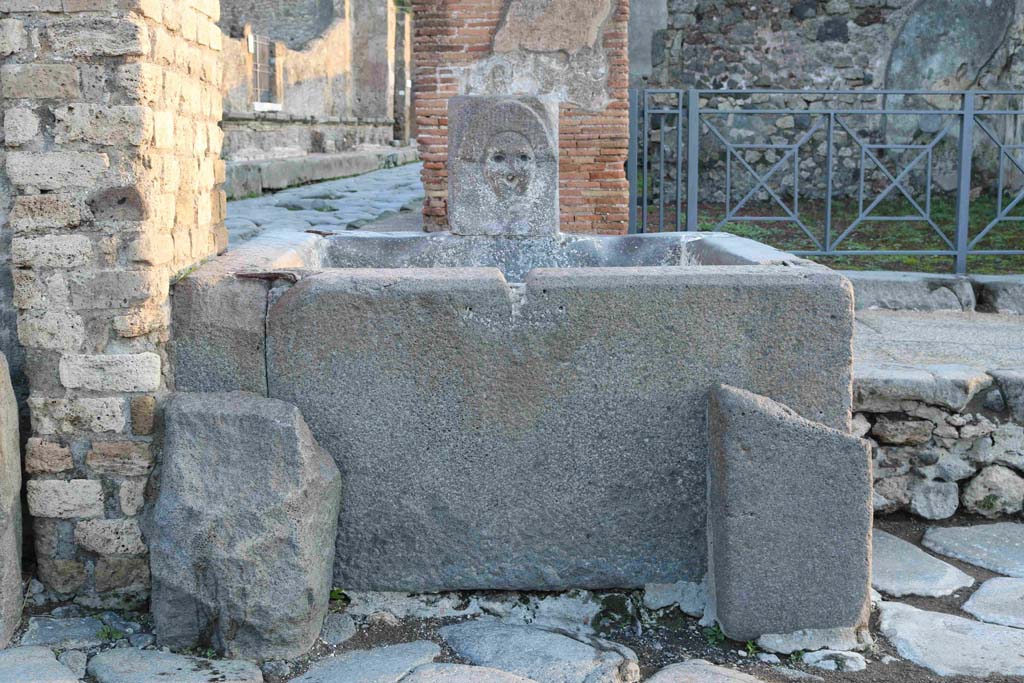 Fountain outside I.4.15 on Via Stabiana. December 2018. 
Looking across Holconius’ crossroads towards fountain. Photo courtesy of Aude Durand.