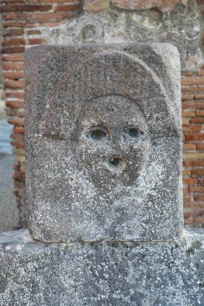Fountain outside I.4.15 on Via Stabiana. 
December 2018. Fountain head with relief of comedy mask. Photo courtesy of Aude Durand.