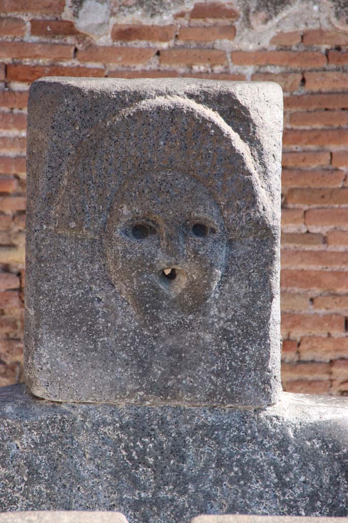 Fountain outside I.4.15 on Via Stabiana. September 2017. Relief of comedy mask.
Photo courtesy of Klaus Heese.