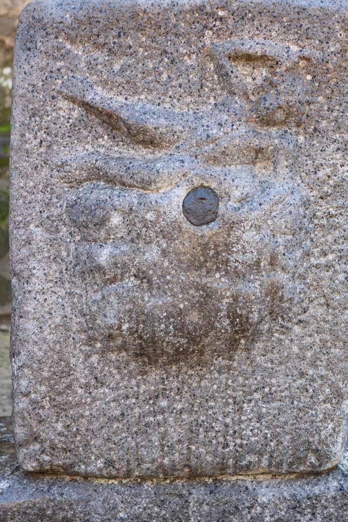 Fountain outside I.12.2 on Via dell’ Abbondanza. December 2018.  
Pilaster with relief of Satyr on rock-fountain or water source. Photo courtesy of Aude Durand.