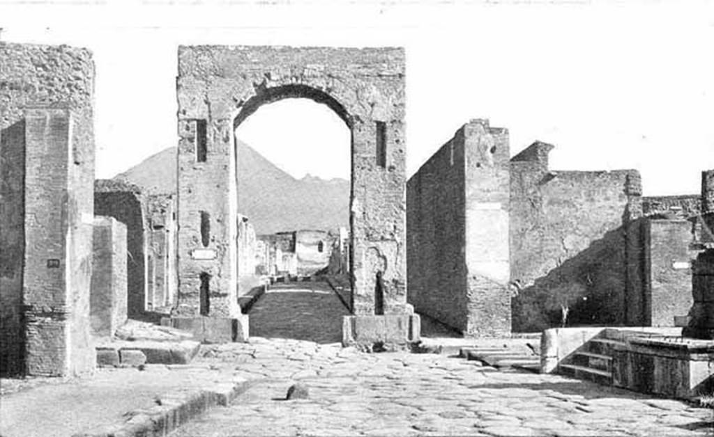 Arch of Caligula. About 1900. South side, looking north to Tower XI, the Tower of Mercurio.
Photo courtesy of Rick Bauer.
D’apres Thedenat, Les arcs de triomphe de Tibère au Forum et de la rue de Mercure ont été utilisés comme colonnes d'ascension pour les eaux. 
On voit mème au pied de l'arc de Mercure l'arrachement des deux fontaines enlevées probablement en mème temps que les marbres du revêtement.
According to Thedenat, the triumphal arches of Tiberius at the Forum and Via Mercurio were used as ascension columns for water.  
We can see also at the foot of the Arch of Mercury the site of the uprooting of the two fountains removed probably at the same time as the marbles of the cladding.
See Thedenat, H., 1906. Pompei: Vie Publique. Paris: Renouard. (Fig. 71, p. 128)