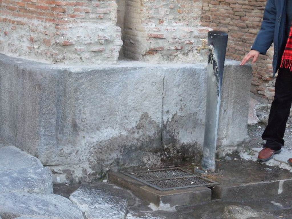 Drinking fountain at base of Arch of Caligula on Via Mercurio at VI.10.10. December 2006. 
The junctions of the original fountain basins can be seen.