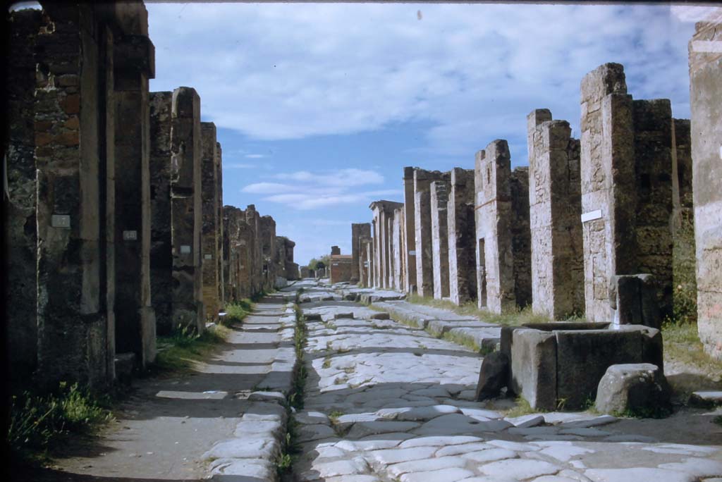 Fountain outside VI.13.7. Via della Fortuna, Pompeii. November 1958. 
Looking west between VII.4 and VI.13 towards junction with Via dell Foro, and Arch on Via Di Mercurio, with VI.13, on right. 
Photo courtesy of Rick Bauer.