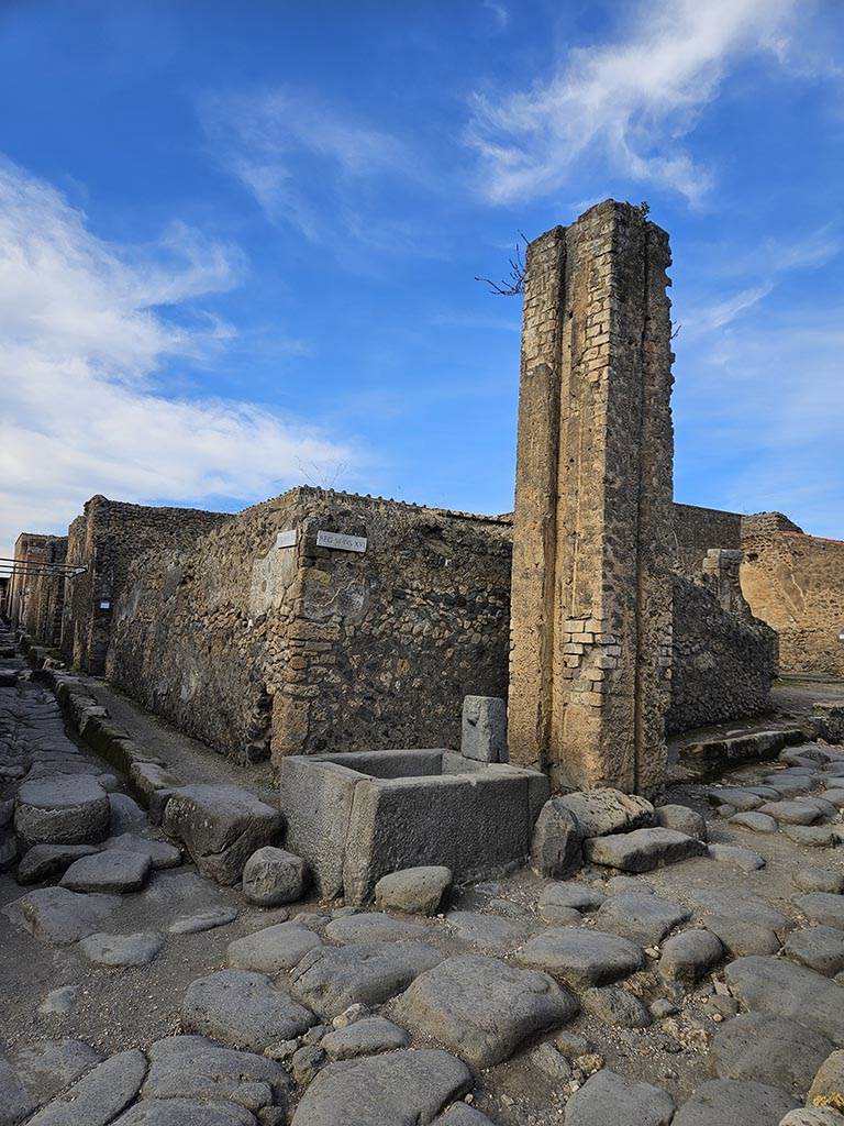 Fountain and water column between VI.16.3 and VI.16.4. November 2024.
Looking north-west from junction of Vicolo di Mercurio, on left, and Via del Vesuvio, on right. 
Photo courtesy of Annette Haug.