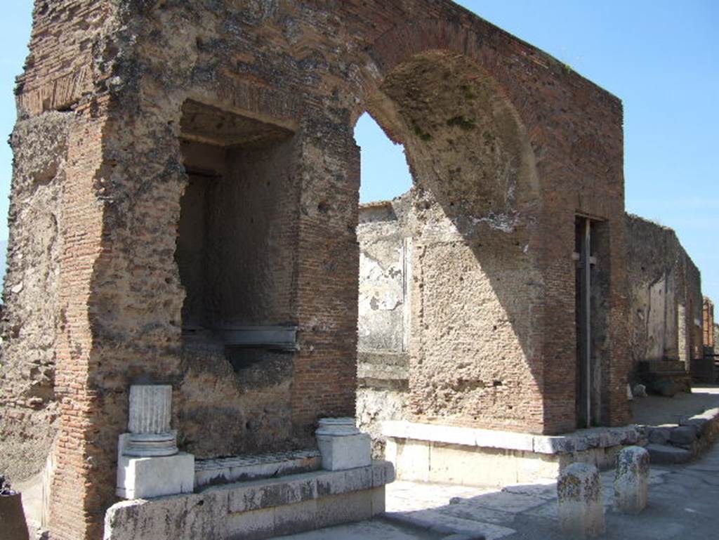 Fountain in arch at north-east corner of Forum. May 2006. Looking south-west.
Nach Eschebach: Die Brunnenbecken am Bogen waren in Gestalt eines Nymphäums mit Grottennischen in Marmor inkrustiert. 
According to Eschebach: The fountain basins in the arch were in the form of a nymphaeum with grotto niches clad in marble. 
See Eschebach, H., 1983. Pompeii, Herculaneum, Stabiae; Bollettino dell’Associazione Internazionale Amici di Pompei 1, p. 26, fig. 37.
