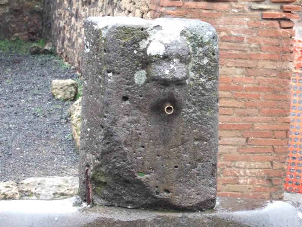 Fountain outside VII.14.13 and VII.14.14 on Via dell’Abbondanza. December 2005. 
Head with helmet, possible relief of Minerva.