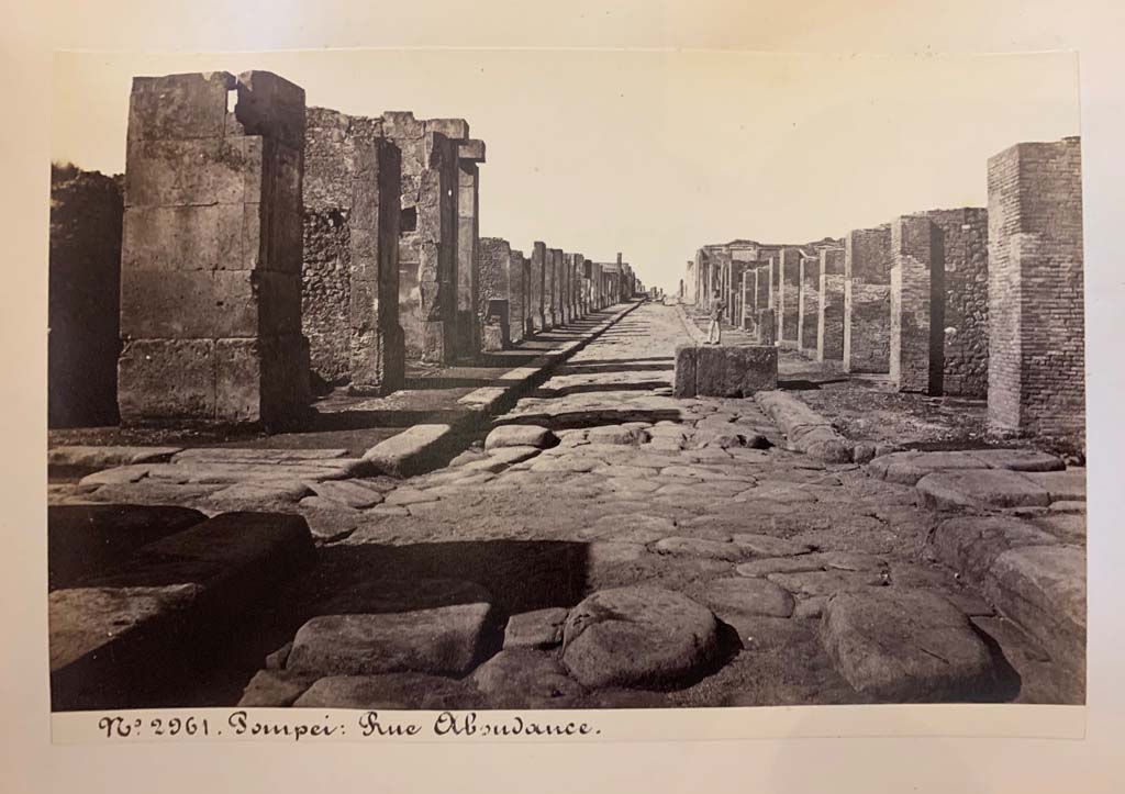 Fountain outside VII.14.13 and VII.14.14 on Via dell’Abbondanza. From an album of Michele Amodio dated 1874, entitled “Pompei, destroyed on 23 November 79, discovered in 1748”. 
Looking west to crossroads with Via dei Teatri, on left, and Vicolo del Lupanare, on right.
Photo courtesy of Rick Bauer.