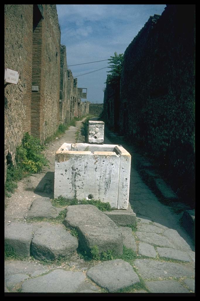 VII.15.1 Pompeii. Fountain in Vicolo del Gallo. VII.7.13 on right.
Photographed 1970-79 by Günther Einhorn, picture courtesy of his son Ralf Einhorn.