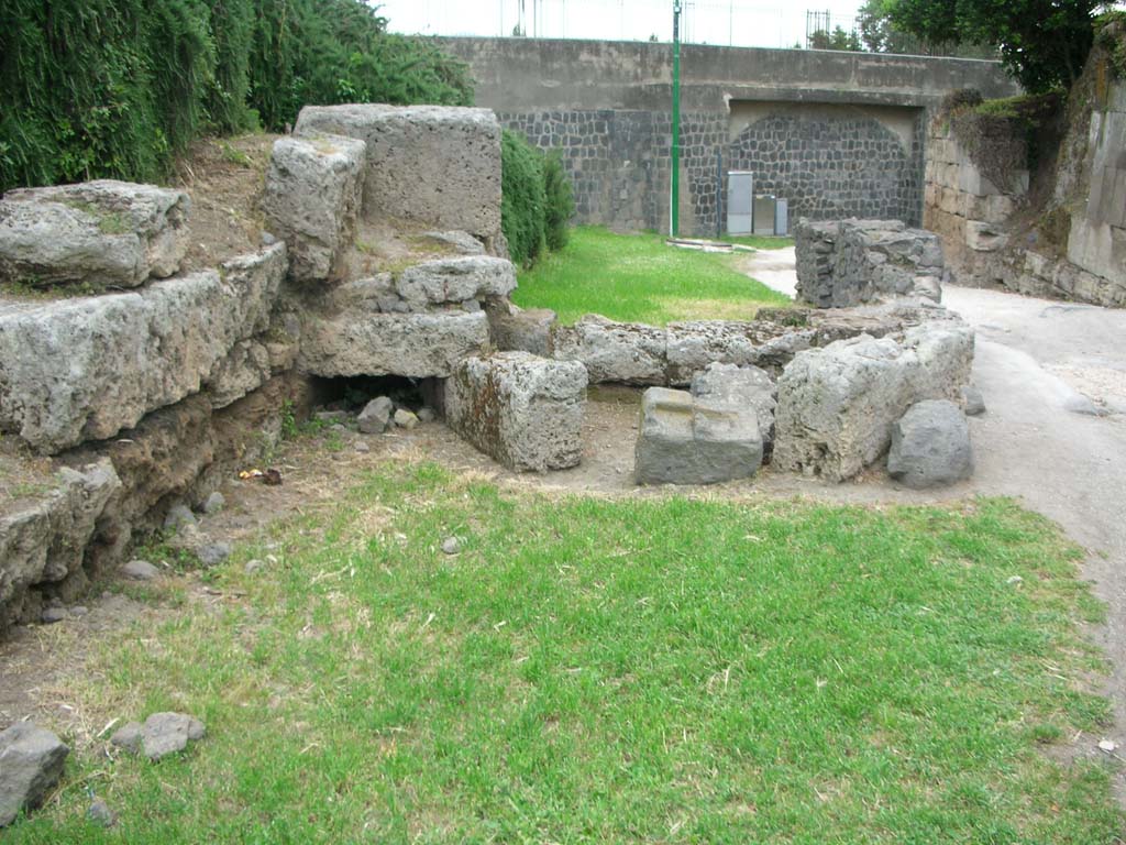 Porta di Sarno or Sarnus Gate. May 2010. 
Remains of entrance to drain (centre left) on north side of gate, looking east. Photo courtesy of Ivo van der Graaff.
According to Van der Graaff –
“The Porto Sarno is perhaps the most damaged of the standing gates. The entire north flank is missing as a result of the Allied bombing in WWII. 
Only the lowest course, parts of the opus incertum vault, and traces of a drain remain.”
See Van der Graaff, I. (2018). The Fortifications of Pompeii and Ancient Italy. Routledge, (p.62, and Fig.3.8).