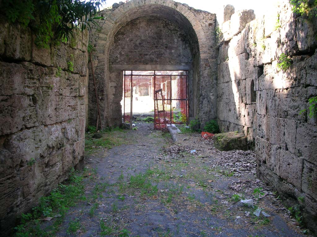 Porta Stabia, Pompeii. May 2010. Looking north through gate, with bastion walls, on left and right. Photo courtesy of Ivo van der Graaff.
According to Van der Graaff –
“The bastions, composed of solid horizontal ashlar masonry, indicated the most powerful exterior line of the fortifications (see Fig. 3.3). 
This must have been a formidable sight. The roadway that first passed through the gate sat a metre lower than today, thereby imparting a tall cavernous appearance to the gate (Note 38). Two closing mechanisms recovered on either side of the gate probably belonged to a double-leafed door closing both thresholds (Note 39). The twin gateways on either end functioned to further mark the entry and exit into the passageway.”
See Van der Graaff, I. (2018). The Fortifications of Pompeii and Ancient Italy. Routledge, (p.53).