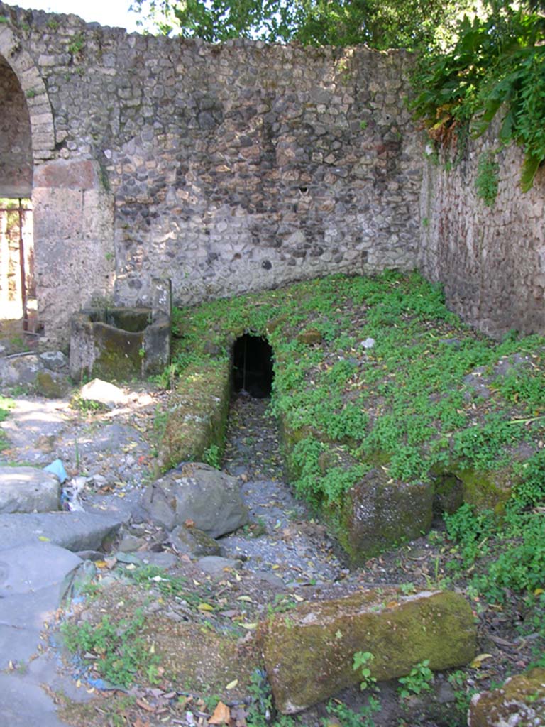 Porta Stabia, Pompeii. May 2010. 
Looking south towards drain on north side of gate, with fountain, on left. Photo courtesy of Ivo van der Graaff.