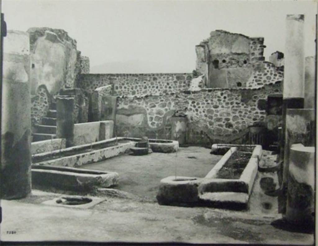 VII.6.7 Pompeii.  About 1910.  Peristyle garden.  
Looking south from north-west corner across two U-shaped masonry flower beds formed by low walls (0.26m. high), originally painted red and filled with soil.
According to Jashemski, the garden at the rear of the tablinum was enclosed on the east, north and west by a portico supported by 7 columns, red below and white above. All lacked capitals at the time of excavation. The rear (south) wall was divided into panels by engaged columns, similar to the columns of the portico. The columns were connected by a low wall, except for a wide entrance to the garden opposite the tablinum: the wall was lower in front of the large room (51) on the east (Jashemski’s plan numbered this room as (b). The panels appear to have been painted with garden paintings. A water channel outlined the garden. There was a cistern opening near the middle column on the north side. Spano found root cavities in the soil of the U-shaped masonry flower beds, but they were not emptied of lapilli, measured or studied. Twenty-eight cavities are indicated on his plan. In the south wall, near the south-east (?) corner of the peristyle was a square niche. 
On page 362, no.76, Jashemski wrote – at the time of excavation only the lower part of the rear (south) wall of the garden at the back of the house still had plaster, this was painted to represent a wooden fence (see also Jashemski, vol.1: fig.44 on page 30) which led Spano to believe that there had been a garden painting above. Nothing remains today, for this house was destroyed in 1943. 
See Jashemski, W. F., 1993. The Gardens of Pompeii, Volume II: Appendices. New York: Caratzas. (p.184) and (362, no.76).
Her sources included – Spano, Notizie degli Scavi, (1910) pp. 456-457; Boyce G. K., 1937. Corpus of the Lararia of Pompeii. (p. 67 no. 289)
The area was devastated in the 1943 bombing.  
The staircase on the east side is the only part still visible in situ.
At the rear of the staircase can be seen two small rooms, the latrine and the kitchen.
According to Boyce: the square niche on the south wall of the peristyle, near the south-west (?) corner, was coated with successive layers of stucco in red green and yellow.
See Boyce G. K., 1937. Corpus of the Lararia of Pompeii. Rome: MAAR 14.  (p.67. no.289).
Photograph courtesy of Soprintendenza Speciale per i Beni Archeologici di Napoli e Pompei. (Negative C359)
