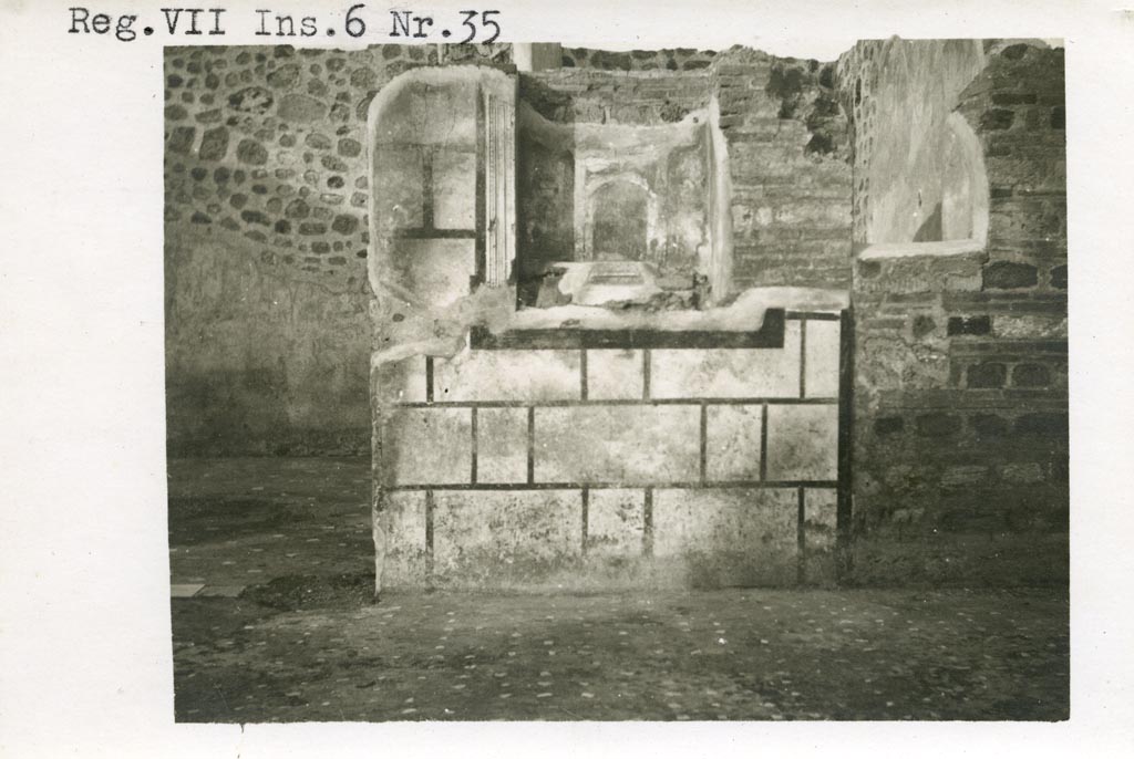 Mystery photo – Warsher numbered this as being from VII.6.35. We hope it is from -
VII.6.30 Pompeii. Pre-1937-39. Looking towards east wall of atrium, room 133/33, with room 139/39 on left.
Photo courtesy of American Academy in Rome, Photographic Archive. Warsher collection no. 560.
According to Boyce, in the east wall of the main room which was entered directly from the fauces was a delicately painted tall, rectangular niche.
He thought this was a Lararium. The white background of the surrounding wall was divided by dark stripes into a series of rectangles.
These rectangles were in imitation of a veneer of slabs of marble or of a wall built of rectangular blocks of stones.
See Boyce G. K., 1937. Corpus of the Lararia of Pompeii. Rome: MAAR 14. (p.67, no.292) 
According to the Notizie degli Scavi, 1910, page 481, in the east wall, to the right of the entrance doorway into room numbered 139, was a delicately painted niche, which served as a sacrarium. 
If anyone can confirm or refute this location, we would be pleased to hear from you.