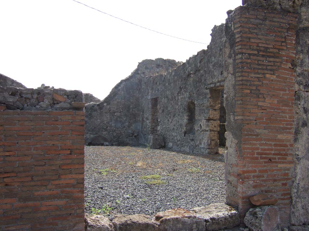 VII.7.19 Pompeii. September 2005. 
West side of atrium, with arched niche (h.0.92, w.0.55, d.0.20, h. above floor 0.55), on south side of kitchen doorway. 
According to Eschebach, on the right were three doorways. In the centre would have been the doorway to the kitchen, between those of cubicula.
See Eschebach, L., 1993. Gebäudeverzeichnis und Stadtplan der antiken Stadt Pompeji. Köln: Böhlau. (p.302)