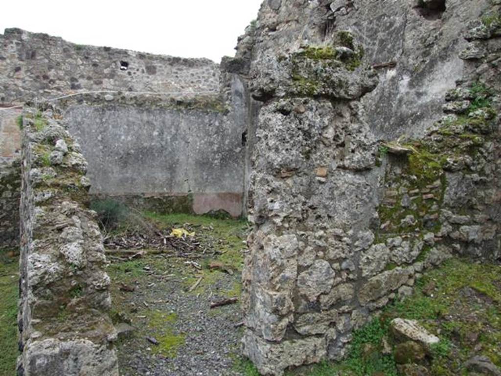 VII.10.12 Pompeii. March 2009. Doorway to triclinium in south-east corner of atrium. 
According to Boyce, on the east wall of the atrium entered at number 12 was a lararium painting on a white background.
The Genius, wreathed and wearing a toga with a fold drawn over his head, held a cornucopia in his left hand.
With his right hand, he poured a libation from a patera onto a blazing altar around which a serpent was coiled.
His head was excellently preserved and exhibited the features of the Roman portrait type of the early Empire.
In the wall above the painting was a niche.
See Helbig, W., 1868. Wandgemälde der vom Vesuv verschütteten Städte Campaniens. Leipzig: Breitkopf und Härtel, (31).
See Fiorelli, G., 1875. Descrizione di Pompei. Napoli, p. 276.
See Boyce G. K., 1937. Corpus of the Lararia of Pompeii. Rome: MAAR 14. (p.69, no.309, numbered as VII.x.9-12).