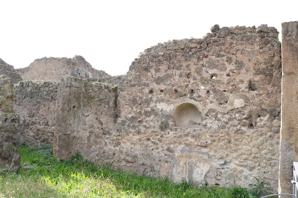 VII.12.12, Pompeii. December 2018. 
Looking towards west wall with arched niche. On the left is the corridor leading to the rear yard, with kitchen and latrine.
Photo courtesy of Aude Durand.