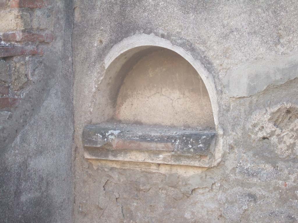 VII.12.15 Pompeii. September 2005. Niche.
According to Boyce – 
in the west wall of the bar-room was an arched niche (h.0.38, w.0.69, d.0.20, h. above floor 1.25) with projecting floor. 
Below the niche was a stucco cornice.
See Boyce G. K., 1937. Corpus of the Lararia of Pompeii. Rome: MAAR 14. (p.71, no.320)
