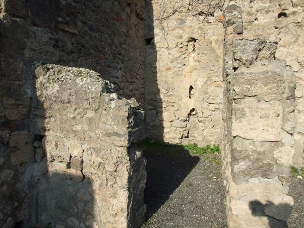 VII.14.2 Pompeii. December 2007. Looking north through doorway to rear room with site of steps to upper floor, and a latrine.
According to Boyce –
a fragmentary painting on the wall of the kitchen appeared to have belonged to a lararium originally painted above it.
Three men (the heads were missing) are busied about a hog: one with staff in his right holds the animal by the ear; 
a second drags on a cord tied about its snout. Below lay the carcass of a slaughtered animal, opened as if for divination from the entrails.
He gave the reference – Helbig 83.
See Boyce G. K., 1937. Corpus of the Lararia of Pompeii. Rome: MAAR 14. (p.71, no.325)