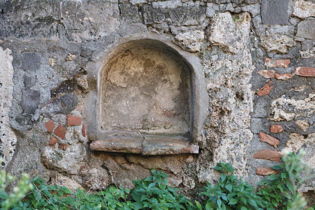 VII.15.11/12 Pompeii. December 2018. Detail of niche in west wall of garden area. Photo courtesy of Aude Durand.
According to Boyce- 
in the west wall of the garden was a smaller arched niche (h.0.45, w.0.45, d.0.20, h. above floor only 0.40), which may also have been a lararium.
He also mentioned the shallow rectangular niche in the east wall of the atrium, see VII.15.12 above.
See Boyce G. K., 1937. Corpus of the Lararia of Pompeii. Rome: MAAR 14.  (p.72, no.333)
See Giacobello, F., 2008. Larari Pompeiani: Iconografia e culto dei Lari in ambito domestico. Milano: LED Edizioni, (p.282 no.V71)