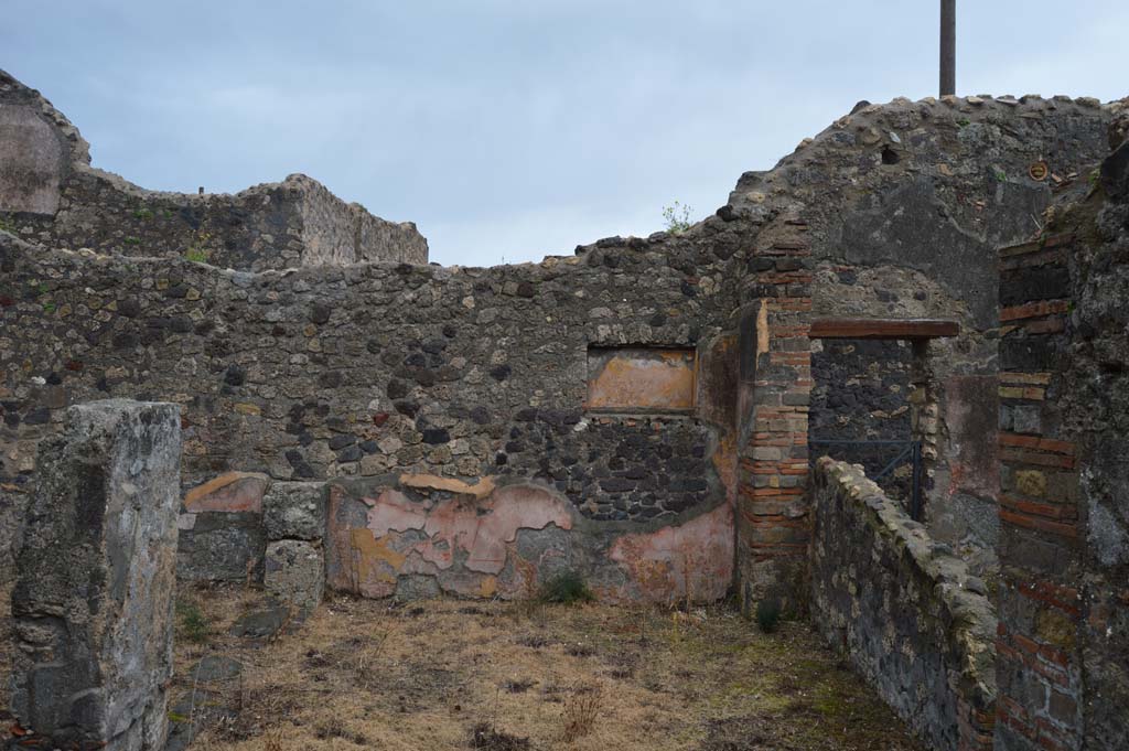 VII.15.12 Pompeii. March 2018. Looking east across room described as “central atrium-like room” or triclinium.
Foto Taylor Lauritsen, ERC Grant 681269 DÉCOR.
According to Boyce – 
in the east wall of the central atrium-like room was a shallow, rectangular niche (h.0.50, w.0.85, d.0.23, h. above floor 1.60) of unusual proportions.
Its walls were coated with yellow stucco and decorated with red stripes; the Bull. Inst. referred to it as “forse un larario”.
See Bullettino dell’Instituto di Corrispondenza Archeologica (DAIR), 1874, 71.
See Boyce G. K., 1937. Corpus of the Lararia of Pompeii. Rome: MAAR 14. (p.72, no.333).
See Giacobello, F., 2008. Larari Pompeiani: Iconografia e culto dei Lari in ambito domestico. Milano: LED Edizioni, (p.282 no.V70)