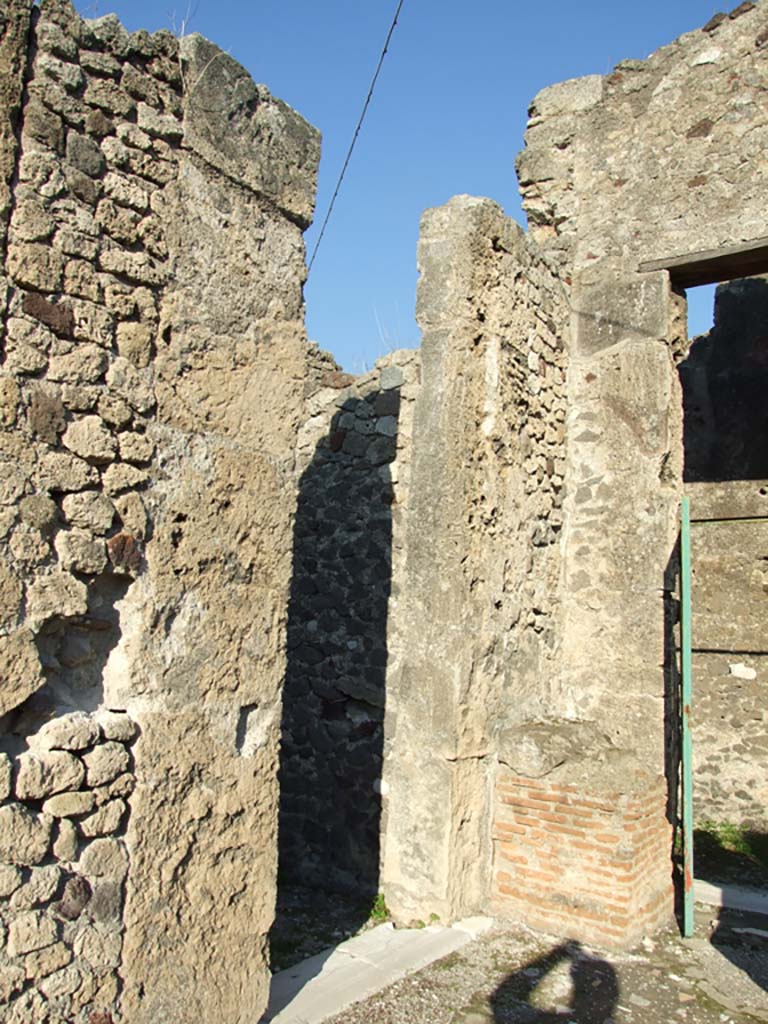 VII.16.13 Pompeii. December 2007. 
Doorway to room 5 on the north-east side of atrium, on the left.
In the centre is the ruined base of a shrine to household gods, and doorway to VII.16.14, is on right.