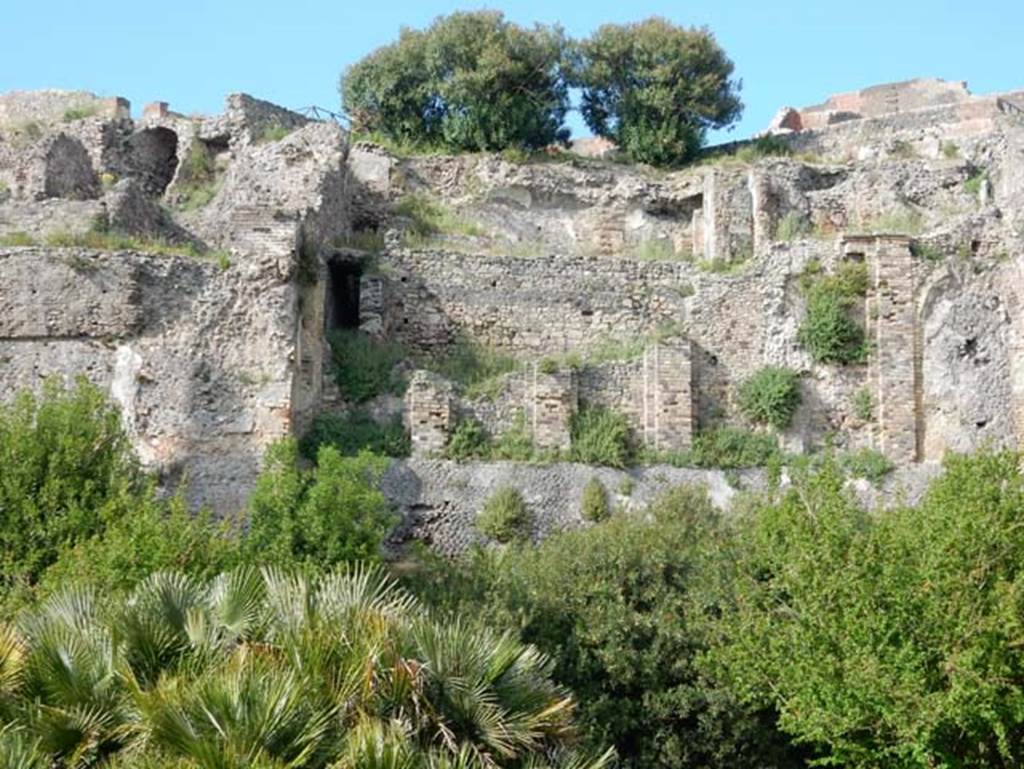VIII.2.16 Pompeii. May 2015. 
Looking north towards lower floor levels beneath area of collapsed terrace garden. Photo courtesy of Buzz Ferebee.
According to Boyce, in a kind of cave beneath the court located behind the large atrium of number 16, on the extreme edge of the slope was a sacrarium of peculiar nature.
Against the rear wall of a narrow passage was built a masonry seat.
In the wall above it, a vaulted opening led into a small cell hewn out of the rock, with its floor 0.50m below that of the outer passage.
A second masonry seat was built within the cell, back to back with that in the outer passage.
The only means of entrance into this inner chamber appeared to have been over these two seats and through the small opening above them.
Within the cella stood a rectangular masonry altar and upon the altar lay a small terracotta altar, a marble ball, and two lamps decorated with reliefs.
One of the lamps was decorated with the relief of Jupiter, the other of a rose.
See Notizie degli Scavi di Antichità, 1890, 290.
See Boyce G. K., 1937. Corpus of the Lararia of Pompeii. Rome: MAAR 14. (p.74, no.344) 
See Giacobello, F., 2008. Larari Pompeiani: Iconografia e culto dei Lari in ambito domestico. Milano: LED Edizioni. (p.246)