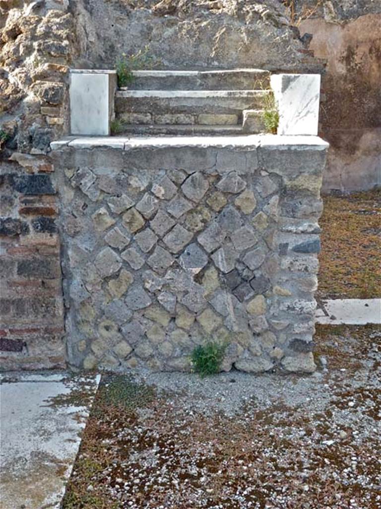 VIII.2.28 Pompeii. September 2011. Base of Lararium. 
In the north-west corner of the atrium is a masonry base. This was the lararium. 
The top of it had three small steps of marble (see below). 
The aedicula that was originally on the base has disappeared. 
On the north wall above the base, when excavated, the figures of the Lares could still be seen.
See Boyce G. K., 1937. Corpus of the Lararia of Pompeii. Rome: MAAR 14. (p74, no.345)
According to NdS – 
“The base was faced with plaster imitating coloured marble, on top of which were three small steps recovered with precious coloured marble.”
See Notizie degli Scavi di Antichità, 1887, (p.511).