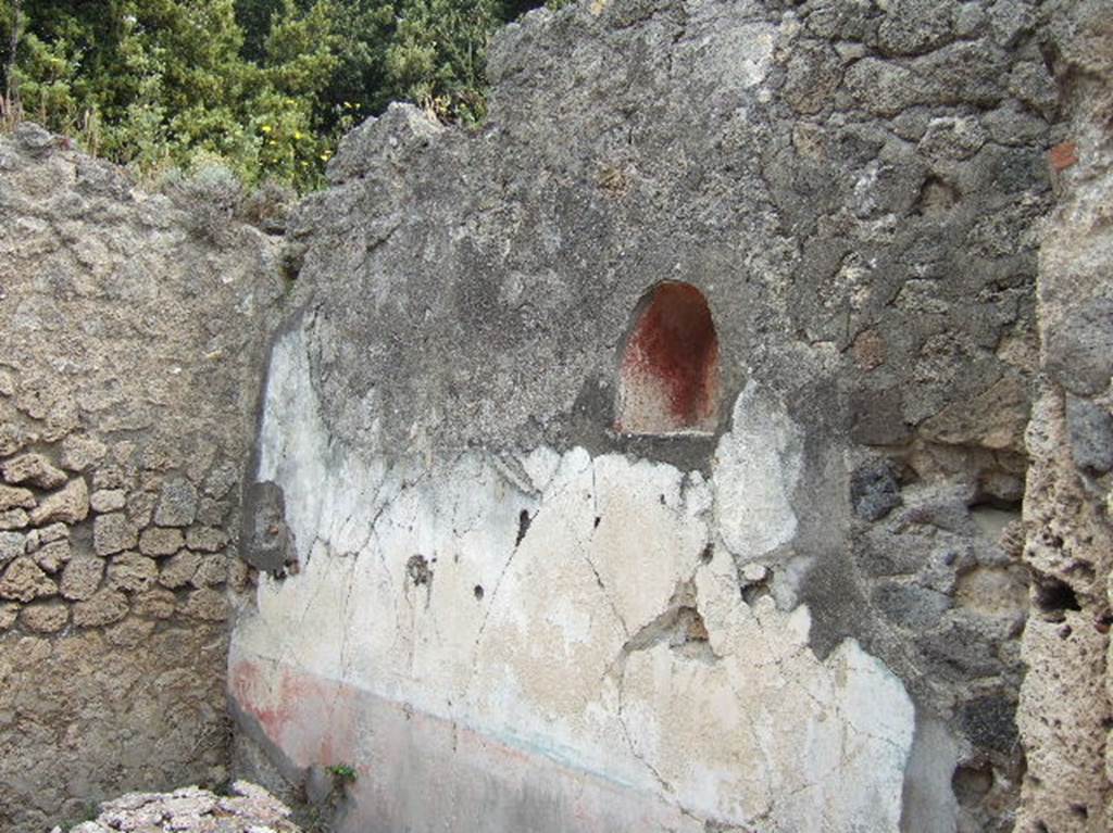 VIII.2.39 Pompeii.  May 2006.  Lararium niche in small room in north east corner of atrium.  This was painted red with a genius in a toga, holding a cornucopia and standing to the left of a round altar.  To the right was a figure in blue and yellow with a diadem and sceptre in the left hand and a patera in the outstretched right hand.  This was possibly Juno.
See Fröhlich, T., 1991. Lararien und Fassadenbilder in den Vesuvstädten. Mainz: von Zabern. (p. 291, L95, T:44,1).
See Boyce G. K., 1937. Corpus of the Lararia of Pompeii. Rome: MAAR 14.  (p. 75, no. 349, pl.19,2).