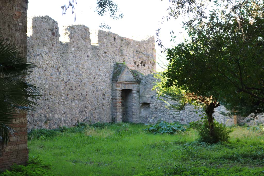 VIII.3.14, Pompeii. December 2018. 
Looking towards north-west corner of garden area, with aedicula niche on west wall. Photo courtesy of Aude Durand.
According to Boyce, in the north-west corner of the garden was a niche (h.1.60, w.0.70, d. varies from 0.40 to 0.55) adorned with an aedicula façade (h.3.25). 
There were two rectangular pilasters supporting a pediment, which was built on the top of a base (h.1.20).
Before the aedicula stood an altar.
See Boyce G. K., 1937. Corpus of the Lararia of Pompeii. Rome: MAAR 14. (p.75, no.351). 
See Giacobello, F., 2008. Larari Pompeiani: Iconografia e culto dei Lari in ambito domestico. Milano: LED Edizioni, (p.282 no.V72)
